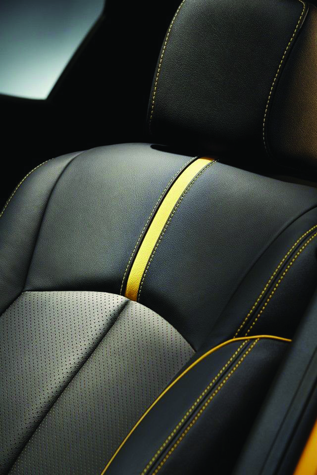 Close-up of leather seat upholstery, perforation, and yellow stitching